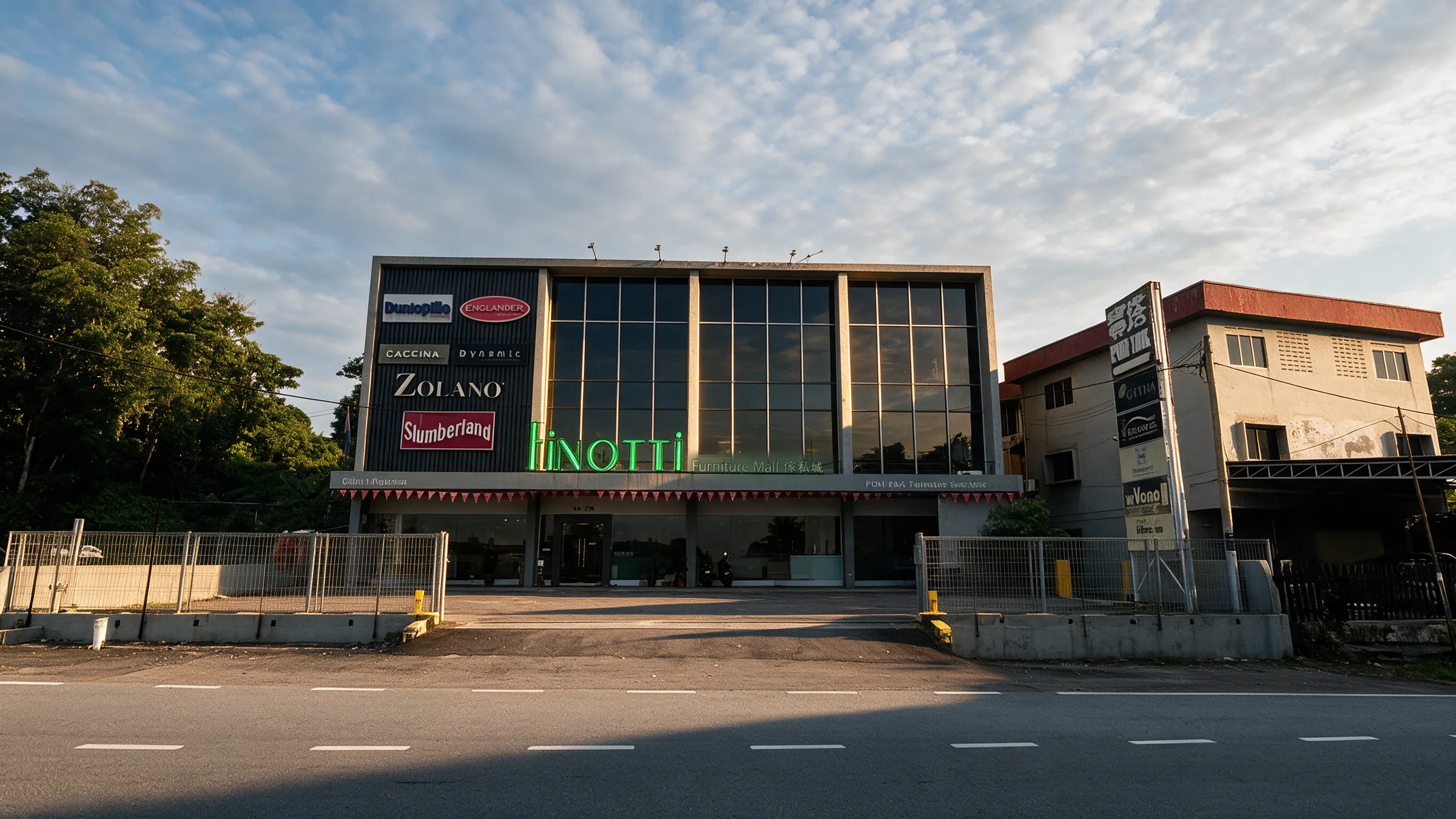 The Finotti building in low golden sunlight, seen from across Jalan Mersing
